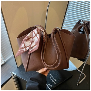 Dettaglio borsa tote in pelle litchi marrone con sciarpa di seta decorativa rosa