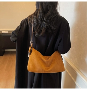 Sac hobo en daim marron porté à l'épaule avec breloque perlée colorée pour l'automne