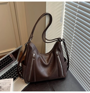 Detailed macro view of dark brown faux leather texture and silver zipper with long fringe