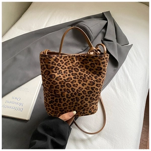 Detail of leopard print bucket bag with brown leather knotted handle and texture