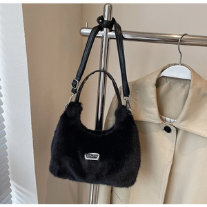 Détail du sac en fausse fourrure noire avec plaque argentée et bandoulière en cuir réglable