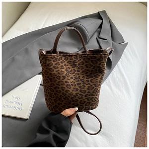 Detail of leopard print bucket bag featuring plush texture and sturdy round handles