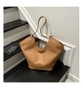 Detailed view of brown woven checkerboard texture and KEKEDOU logo on bucket bag