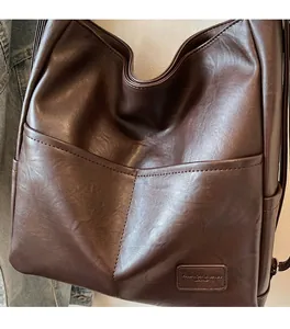 Detailed macro view of soft textured brown leather surface and functional front pockets