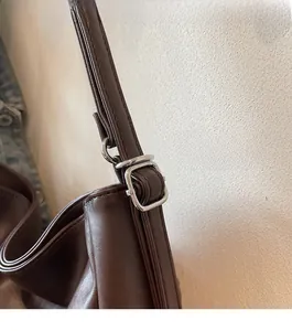 Macro shot of silver metal buckles and textured dark brown leather strap stitching