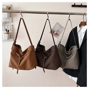 Close-up of retro matte leather tote bags in caramel, dark brown and sage green