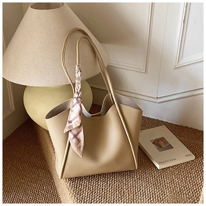 Dettaglio borsa tote beige crema in pelle grana litchi con foulard di seta rosa decorativo