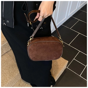 Detailed view of dark brown frosted suede crossbody bag with gold metal zipper and strap