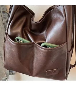 Macro detail of dark brown retro tote bag showing dual front pockets for phone storage