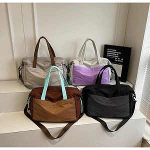 Detail showing four stylish travel tote bags in nylon with various patchwork color schemes