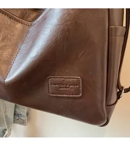 Detailed close-up of dark brown leather tote texture and embossed fashion brand tag