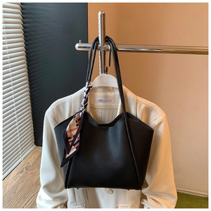 Dettaglio della borsa tote in pelle nera martellata con foulard decorativo in seta a motivi