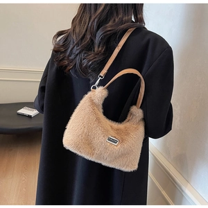 Détail du sac à main en peluche camel avec plaque argentée et bandoulière en cuir