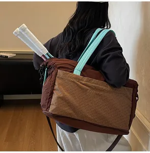 Detail showing high-capacity travel tote bag with specialized compartment for tennis rackets