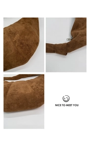 Close-up of suede shoulder bag stitching, knotted strap, and metal zipper details