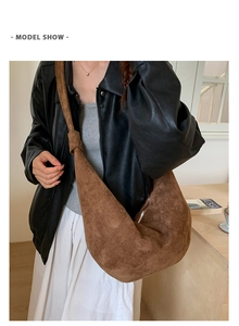 Close-up of brown suede croissant shoulder bag showing texture and knot detail