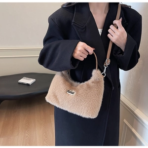 Détail du sac à main en peluche chameau avec logo en métal et bandoulière en cuir