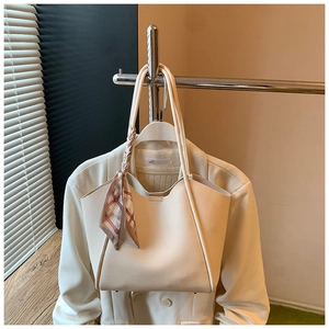 Dettaglio della borsa tote in pelle bianco avorio con foulard a quadri sul manico
