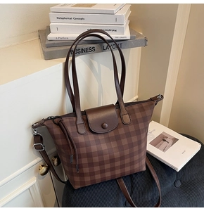 Detailed view of brown checkered tote bag with metal zipper and snap button closure