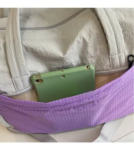 Detail of grey travel tote with checkered pocket showing large capacity for a tablet