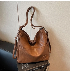 Detail of vintage brown PU leather tote bag with pocket and silver hardware