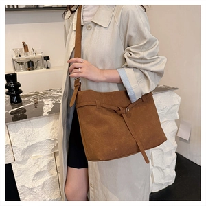 Detail showing the brown frosted leather texture and metal buckle on the crossbody tote bag