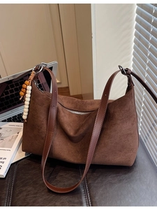 Grand sac fourre-tout en daim marron avec pampille en perles sur bureau avec ordi