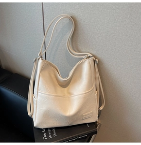 Detailed close-up of cream white tote bag featuring front dual pockets and soft PU leather texture