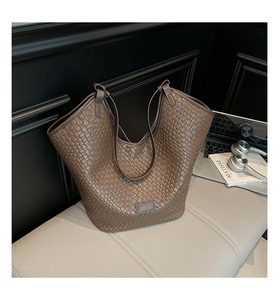Detail shot of the brown woven texture and brand logo on the large Hobo shoulder bag
