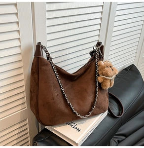 Brown suede crescent bag with silver chain strap and cute bear charm detail