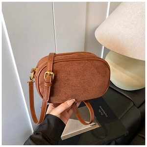 Close-up of brown frosted leather crossbody bag with golden zipper and adjustable strap