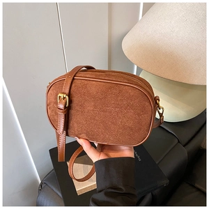 Detail of vintage brown suede crossbody bag showing rich leather texture and metallic buckle