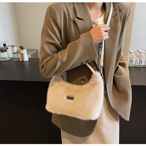 Détail du sac bandoulière en fausse fourrure crème avec plaque logo en métal et lanière