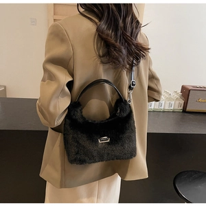 Détail du sac bandoulière en peluche noire avec bandoulière réglable et plaque en métal