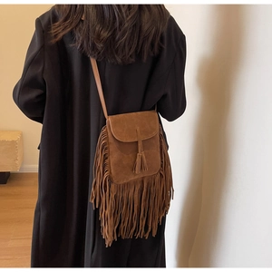 Sac bandoulière bohème en daim marron avec de longues franges sur un mannequin
