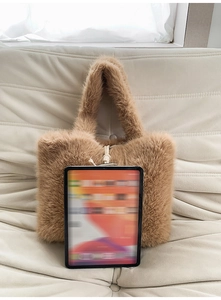 Detail einer flauschigen, kamelbraunen Kunstfelltasche mit weicher Textur auf Sofa