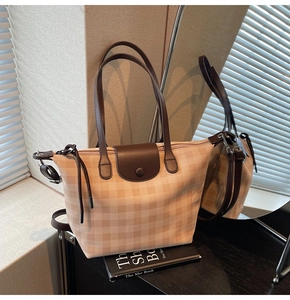 Detail view of plaid tote bag featuring checkered pattern and premium leather straps