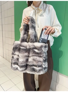 Détail d'un grand sac fourre-tout en fausse fourrure grise et blanche à rayures dégradées