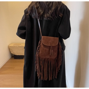 Gros plan sur le sac bandoulière en daim marron avec longues franges et détails bohèmes