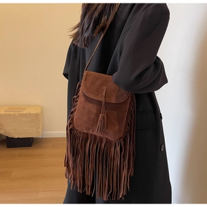 Gros plan du sac bandoulière en daim marron avec détails de franges bohèmes