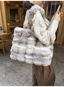 Détail d'un grand sac cabas en fausse fourrure à rayures grises avec une tenue d'automne