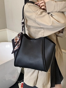 Grande borsa tote nera in pelle martellata con foulard di seta indossata da modella