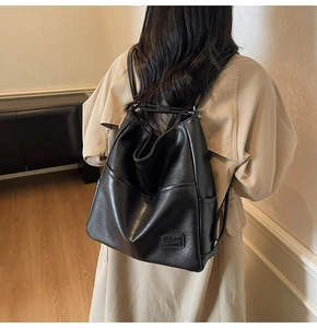 Close-up of black leather backpack detail featuring the Fashion & Bags logo patch