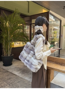 Détail du sac cabas en fausse fourrure à rayures grises et blanches au café en plein air