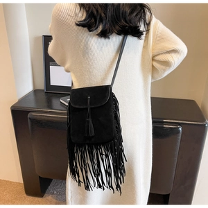 Détail du sac bandoulière bohème en daim noir avec de longues franges sur un mannequin