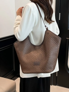 Brown woven tote bag for women featuring a spacious bucket design and refined texture