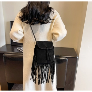 Détail du sac bandoulière vintage en daim noir avec de longues franges bohèmes