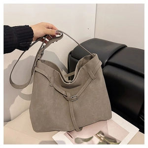 Detail view of large grey frosted leather bucket bag with decorative wrap straps and buckle