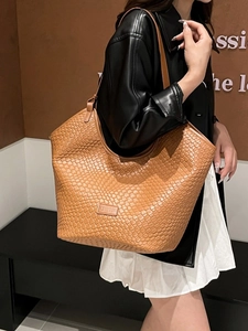 Caramel brown woven leather tote bag with shoulder strap for daily commuting