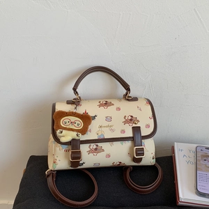 Détail d'un sac à dos à motifs de dessins animés avec poignées cuir et ours en peluche